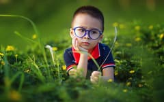 Мальчик в очках на поляне